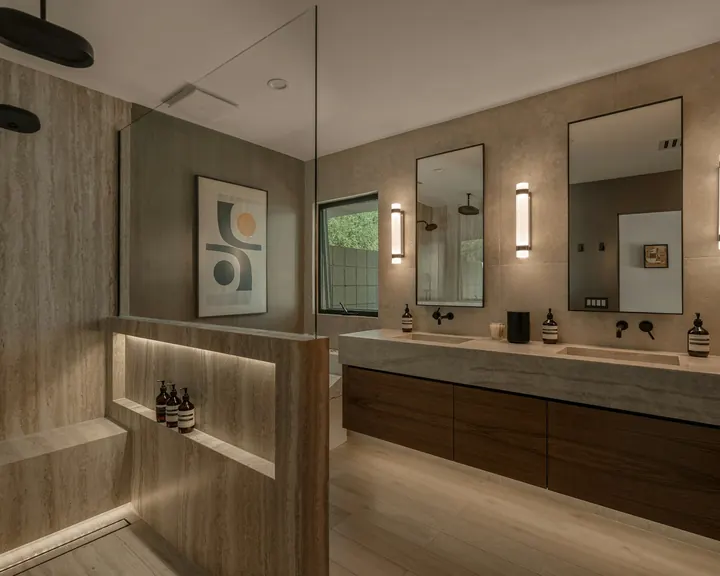 Salle de bains en travertin avec double vasque, douche ouverte et éclairage indirect